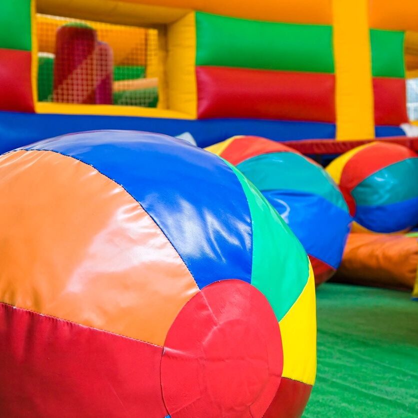 Close-up of colorful inflatable balls in a play area.